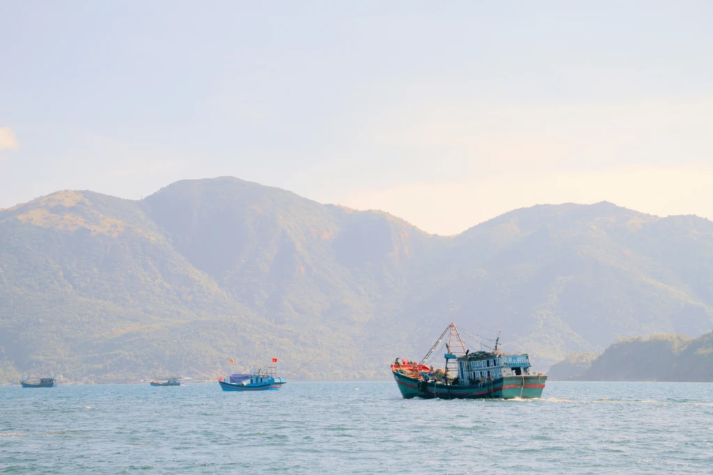 Tàu cá hoạt động trên vịnh có núi bao quanh
