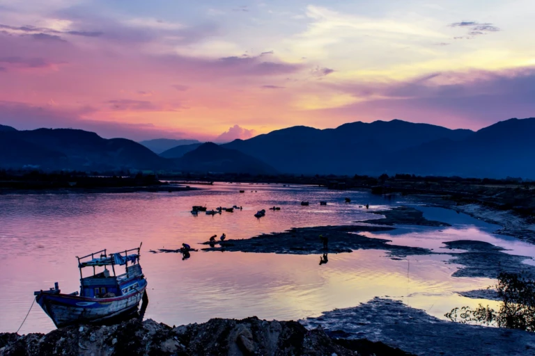 Thuyền nhỏ trên vùng nước cạn lúc hoàng hôn