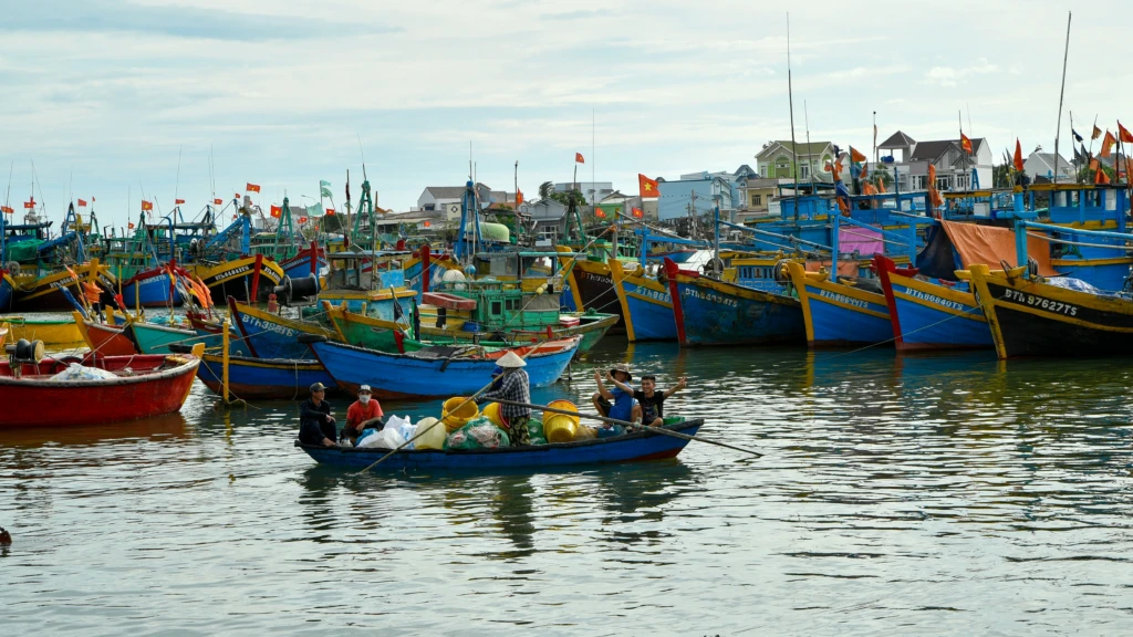Mặt biển lúc bình minh với thuyền nhỏ ngoài xa
