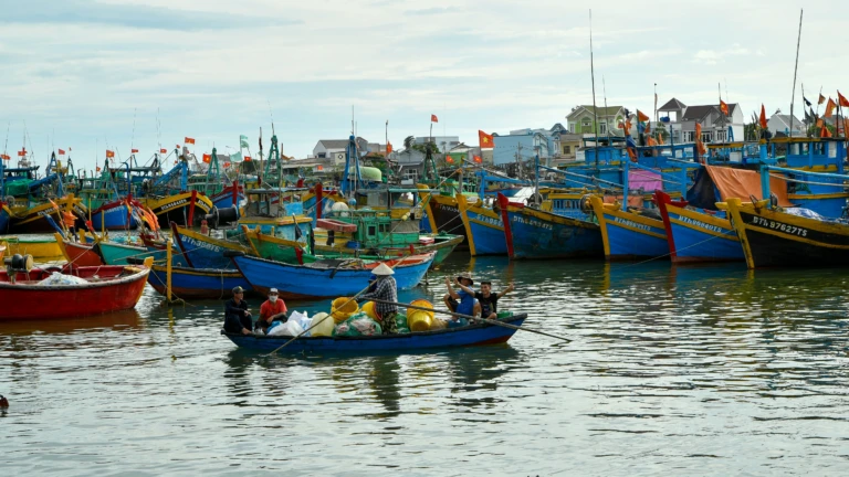 Mặt biển lúc bình minh với thuyền nhỏ ngoài xa